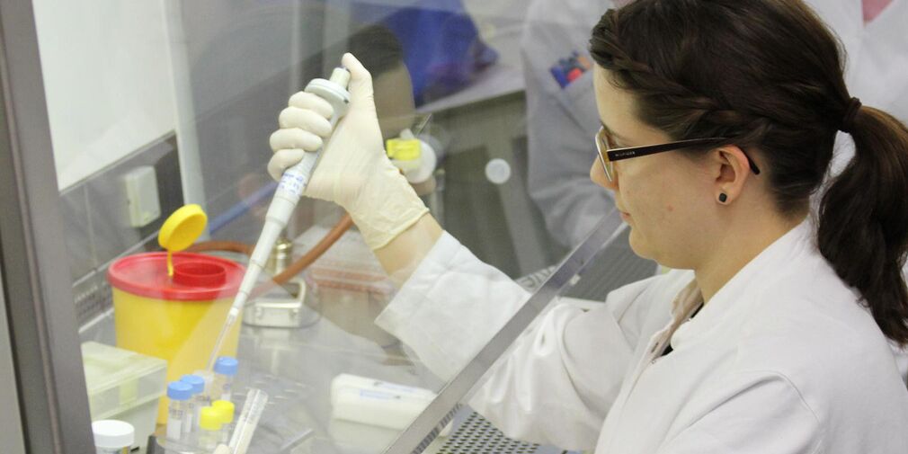 Ein Foto von einer Frau mit Pipette im Labor.